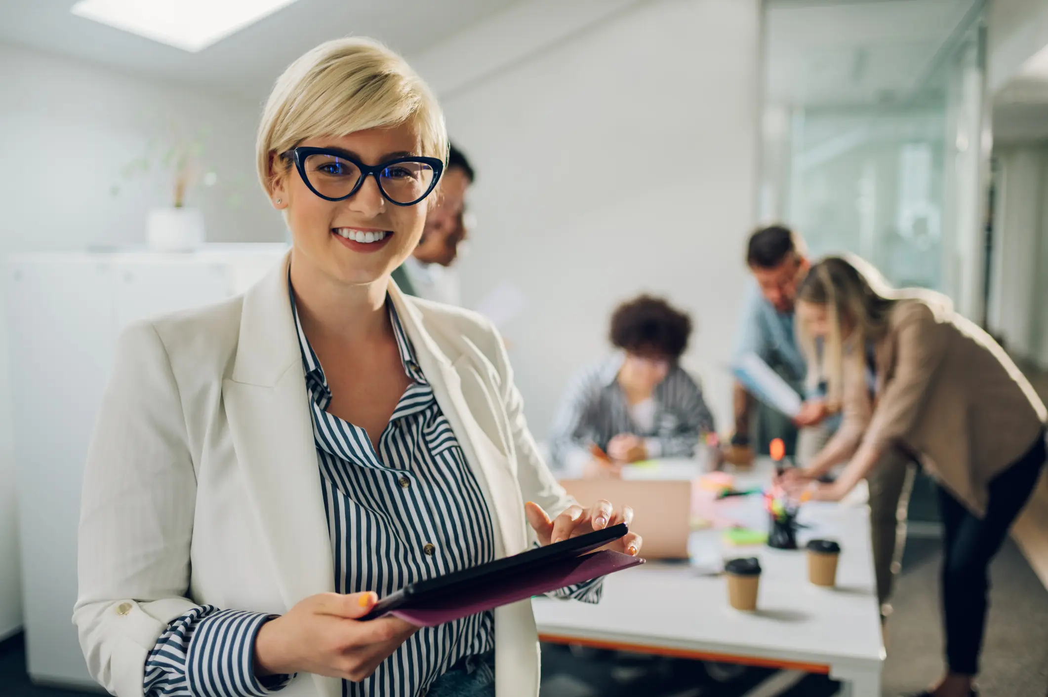 Smiling professional woman holding a tablet.