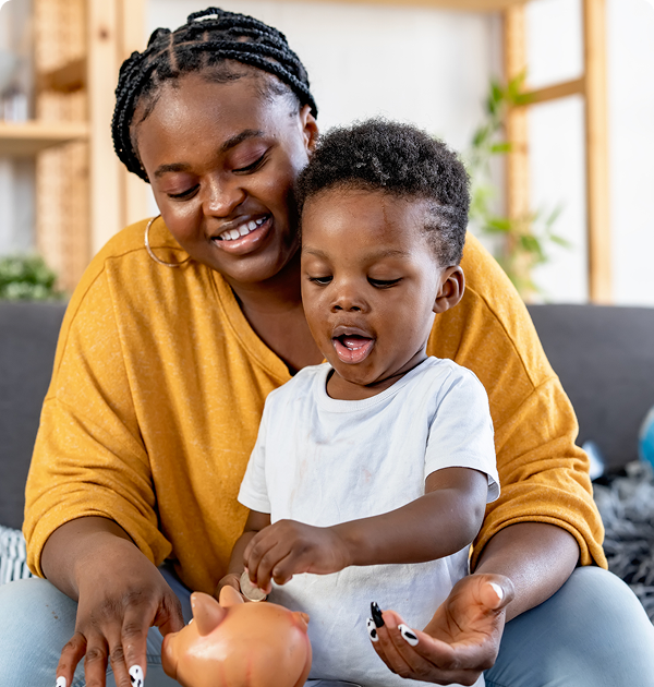 Parent and child playing with piggy bank.