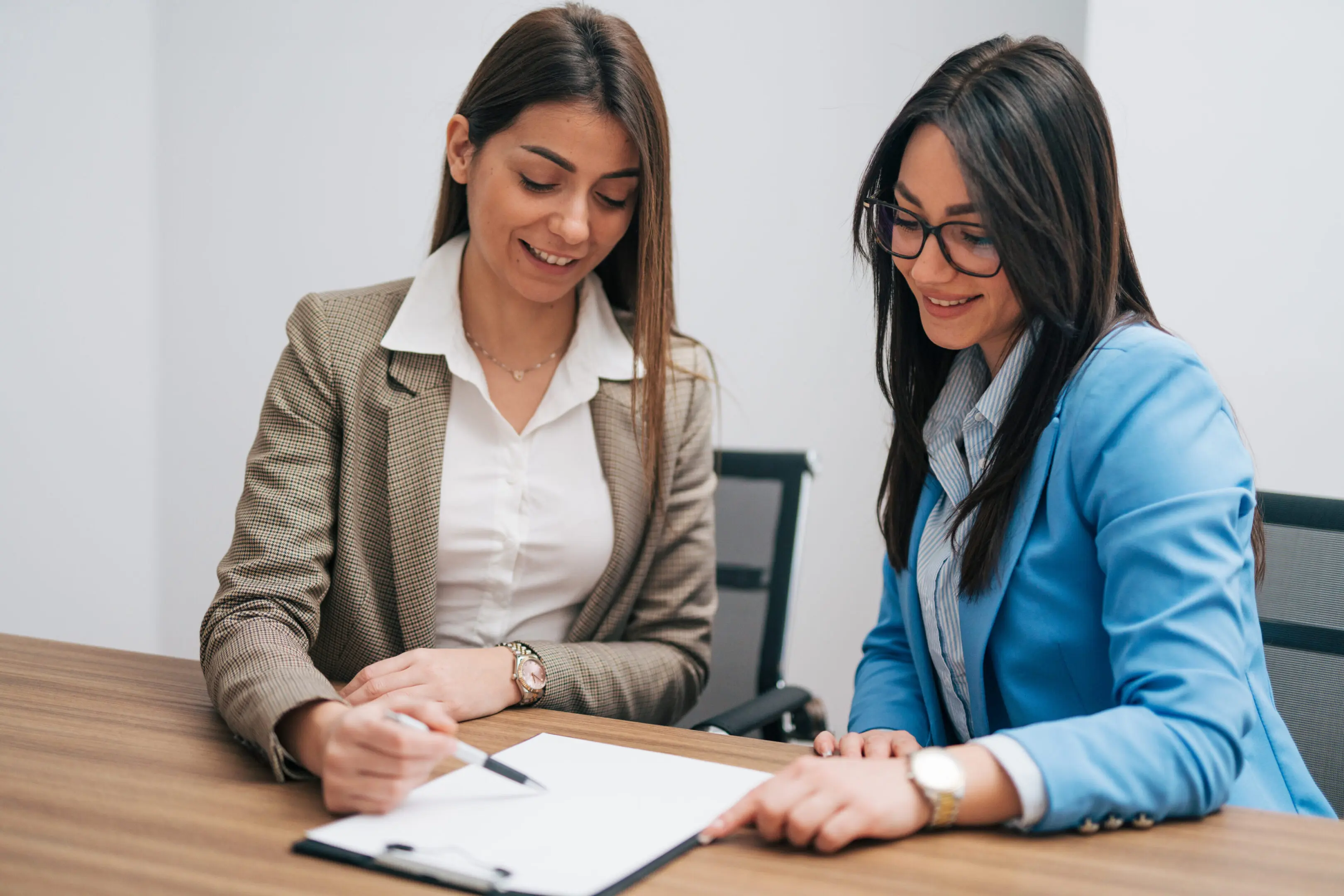 Two young business women working together in a modern office